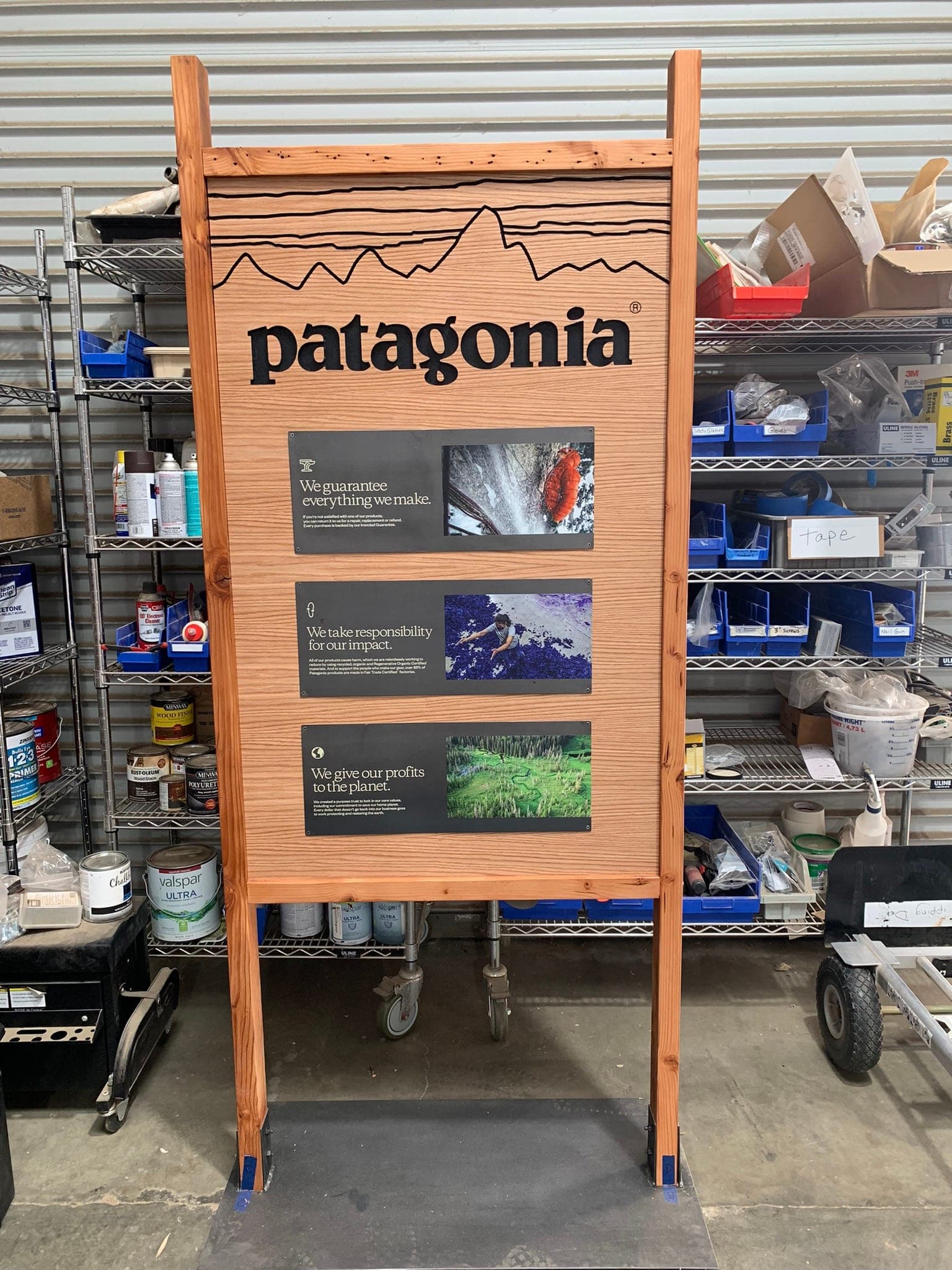 Patagonia retail pillar — three black panels mounted on a custom wood frame with manifesto headlines.