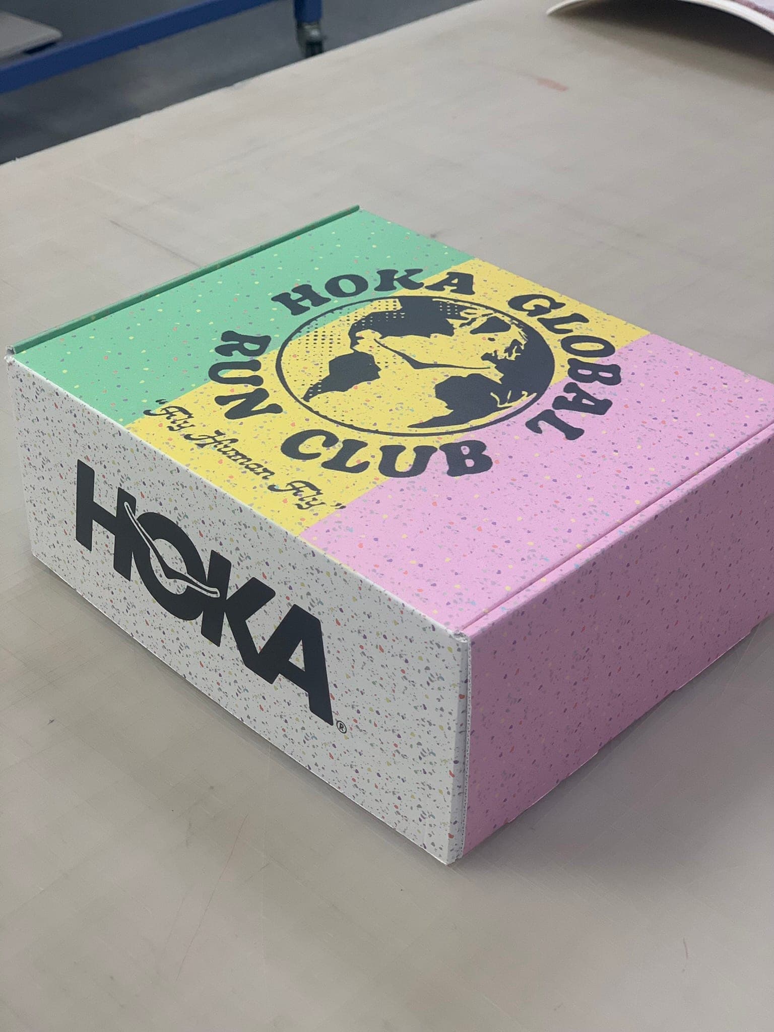 Custom HOKA Global Run Club box — speckled white with mint, yellow, and pink quadrants.